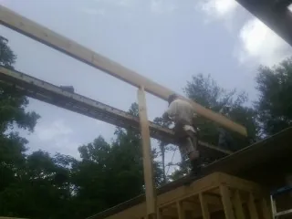 Carpenter setting a ridge beam over a new addition frame — Ice Dam Removal by Roofing Brothers in Colleyville