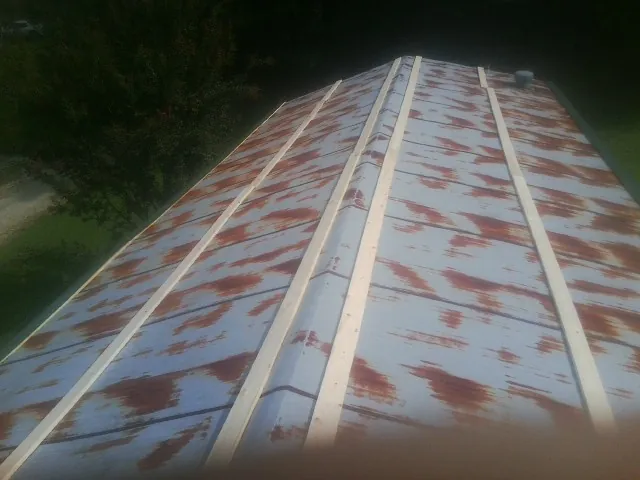 Rusted metal roof panels with new wood purlins before replacement — Storm Damage Roof Repair in Colleyville by Roofing Brothers