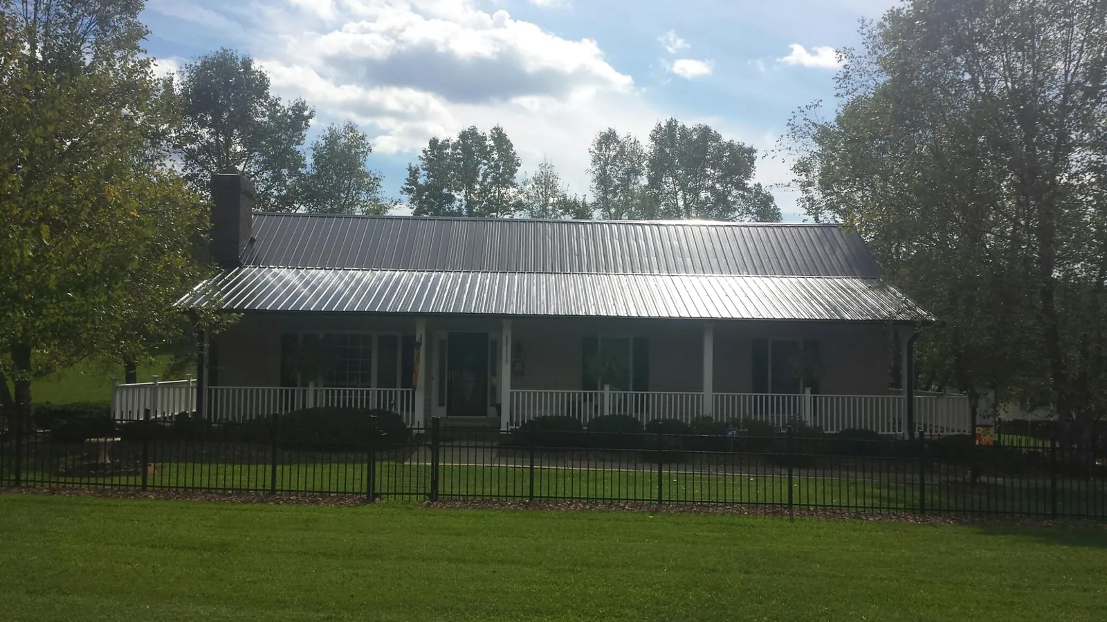 Gray metal roof on a brick ranch with a full width front porch — Gutter Guard Installation work by our crew in Colleyville